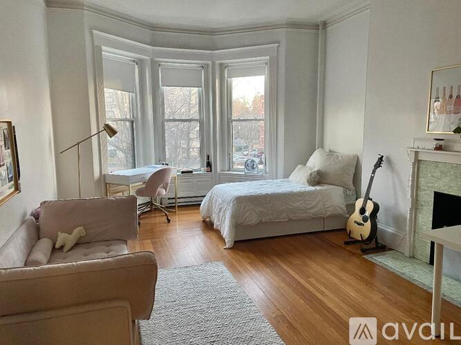 A bedroom with a large bed and a fireplace with a guitar on it.