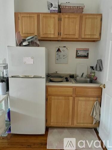 A kitchen with wooden cabinets and a white fridge.