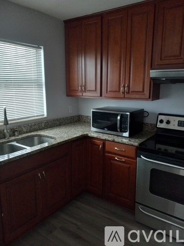 A kitchen with brown cabinets and a stove top oven.