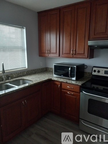 A kitchen with brown cabinets and a stove top oven.