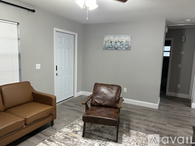 A living room with a brown leather chair and a brown sofa.