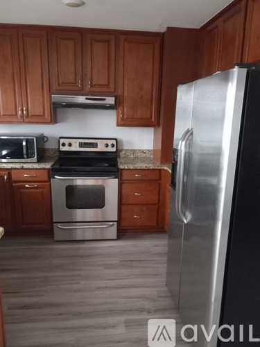 A kitchen with a stove, oven, microwave, and refrigerator.