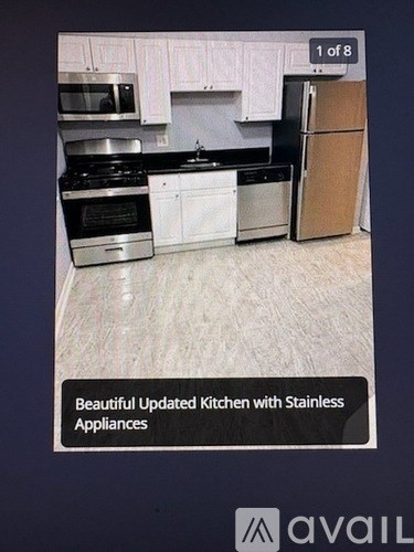 A kitchen with stainless steel appliances and white cabinets.