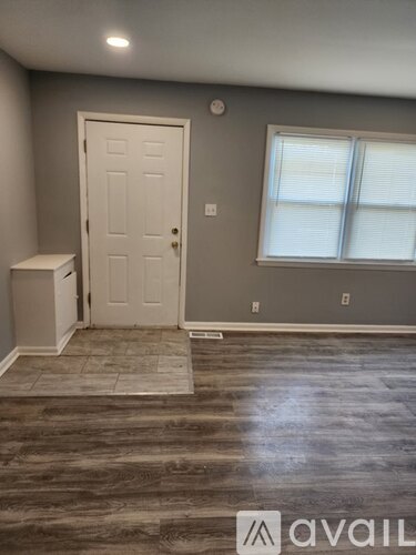 A room with a door, a window, and a bench.