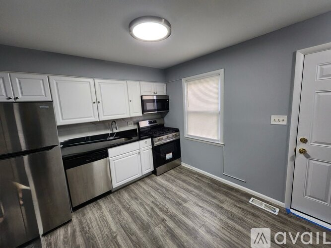 A kitchen with stainless steel appliances and white cabinets.