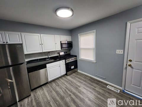 A kitchen with stainless steel appliances and white cabinets.