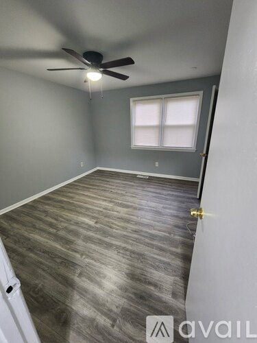 A room with a ceiling fan and a window.