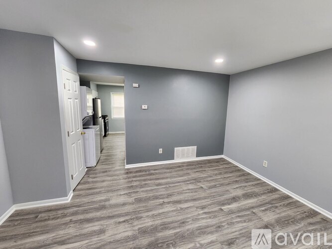 A spacious room with grey walls and a wooden floor.
