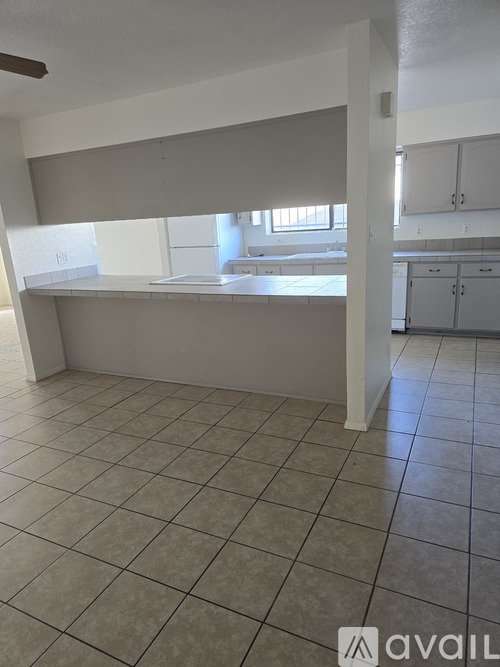 A room with a tiled floor and a window covered with blinds.