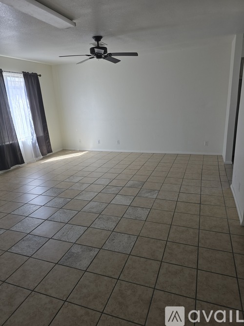 A room with a ceiling fan and tiled flooring.