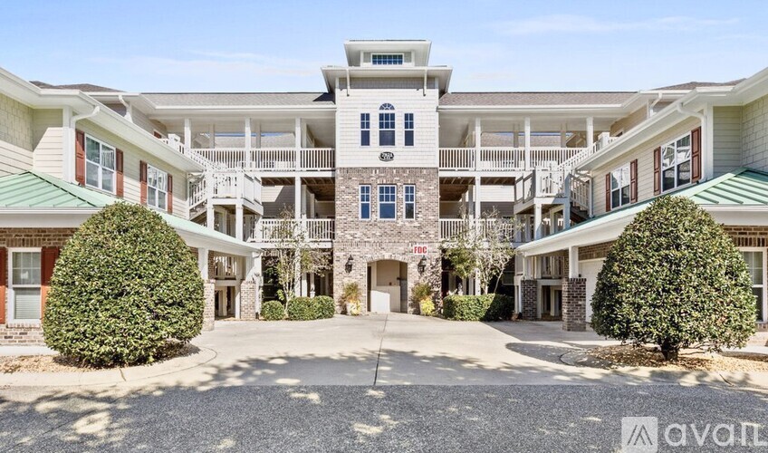 A large, multi-level residential building with a central entrance and balconies on each floor.