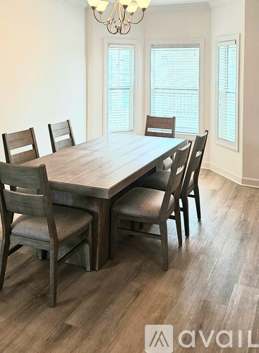 A dining room with a wooden table and chairs.