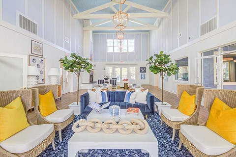 A living room with a white sofa and yellow pillows.