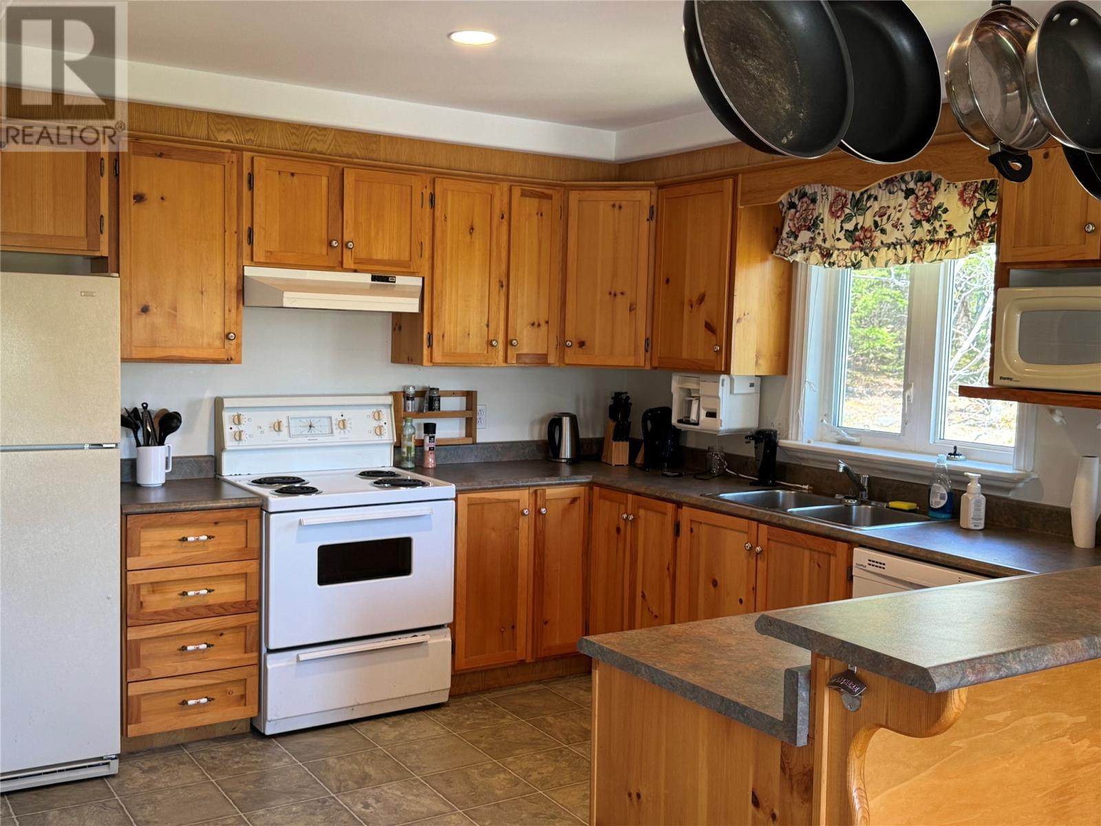 A kitchen with wooden cabinets and a white refrigerator.