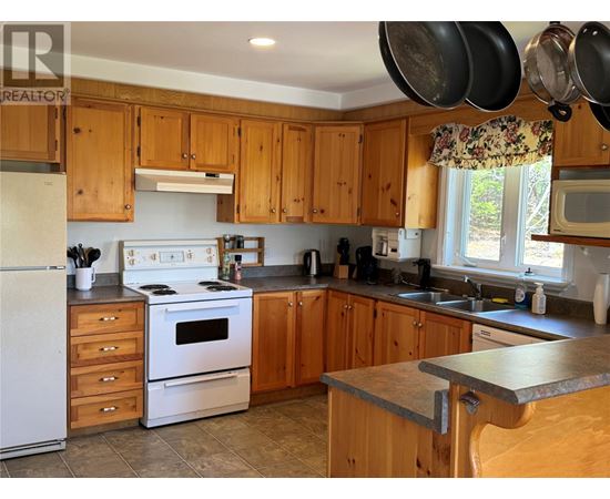 A kitchen with wooden cabinets and a white refrigerator.