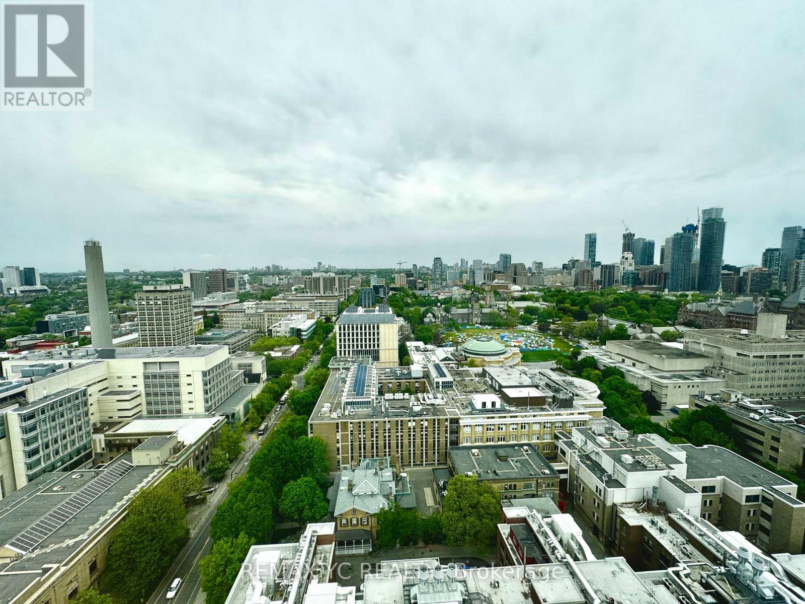 A cityscape with a mix of modern and older buildings, with a cloudy sky overhead.