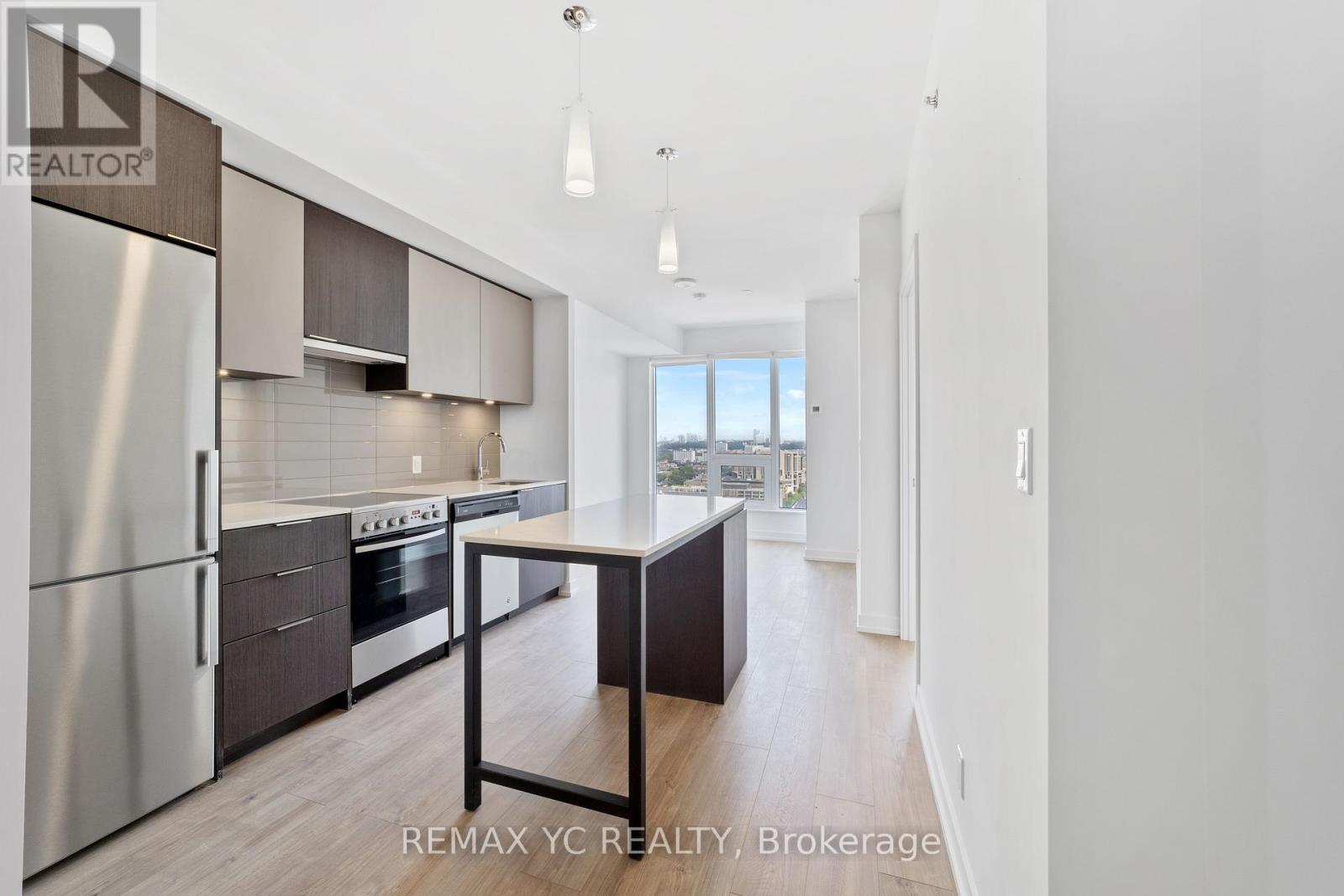 A modern kitchen with stainless steel appliances and a dining table.