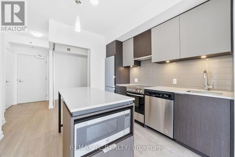 A modern kitchen with a stainless steel dishwasher and microwave.
