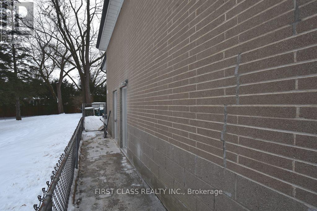 A brick building with a sign that says "First Class Realty Inc., Brokerage.".