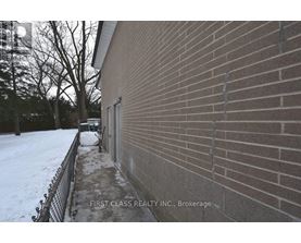 A brick building with a sign that says "First Class Realty Inc., Brokerage.".