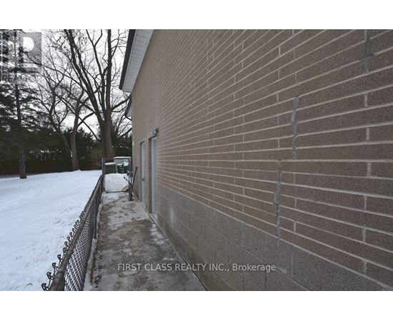 A brick building with a sign that says "First Class Realty Inc., Brokerage.".