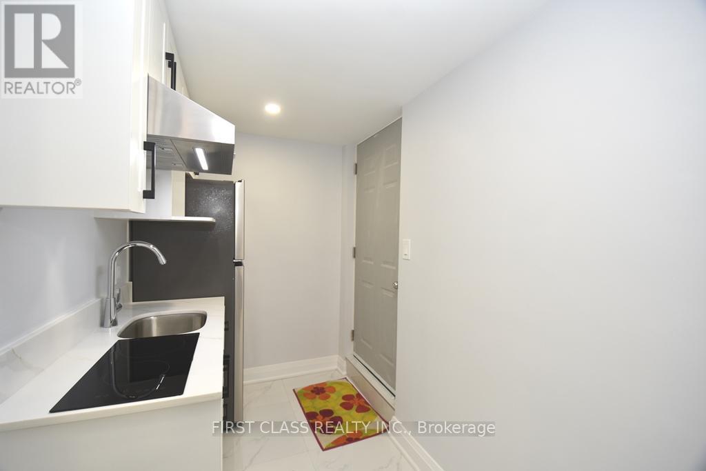 A small kitchen with a sink and a refrigerator.