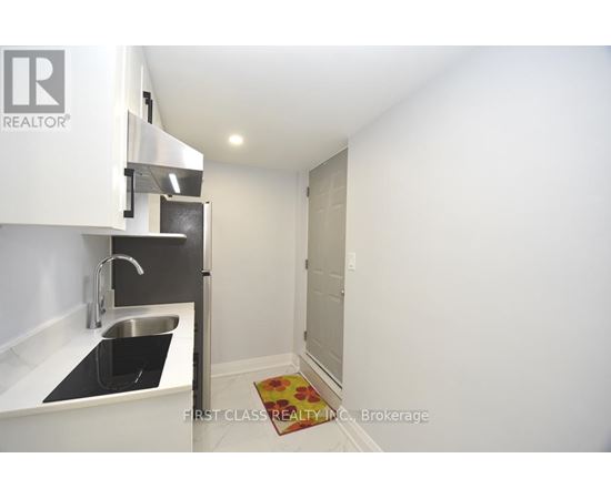 A small kitchen with a sink and a refrigerator.