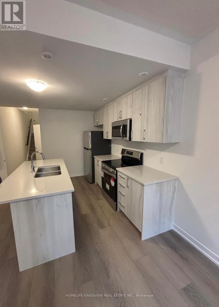 A kitchen with white cabinets and a black refrigerator.