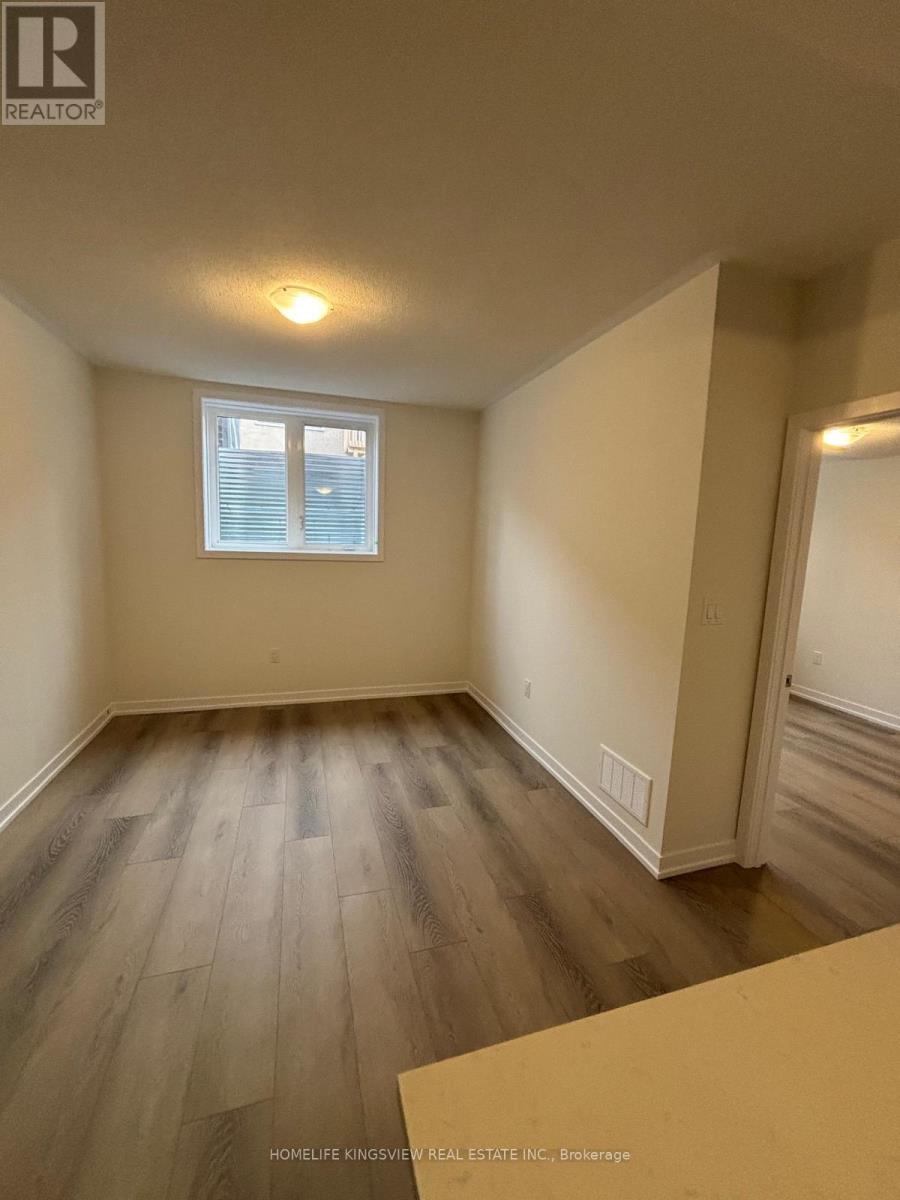 A room with wooden flooring and a window with blinds.