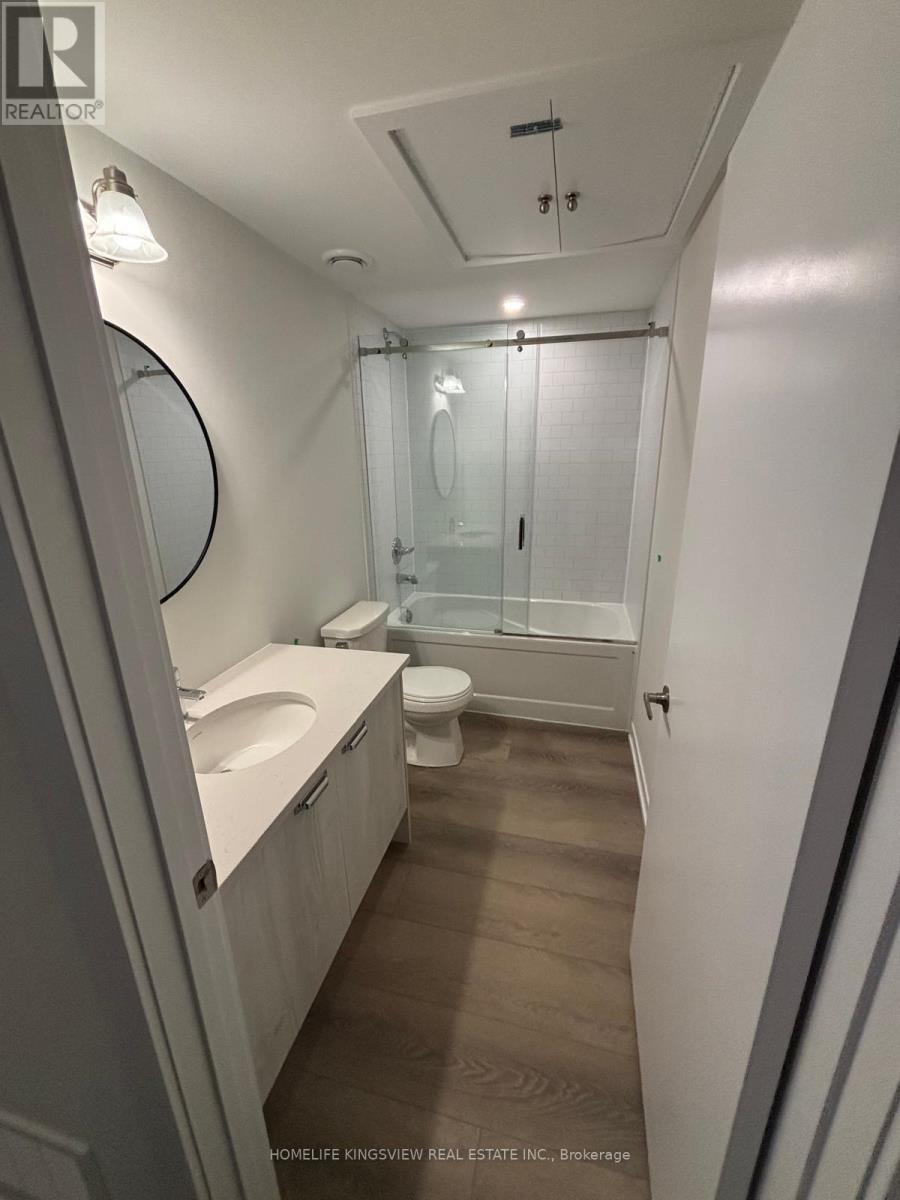 A bathroom with a toilet, sink, and shower.