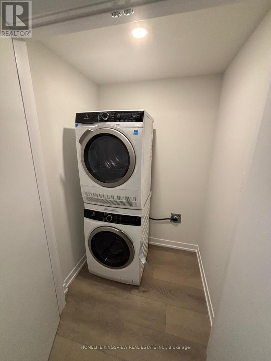A stacked washer and dryer in a small room.