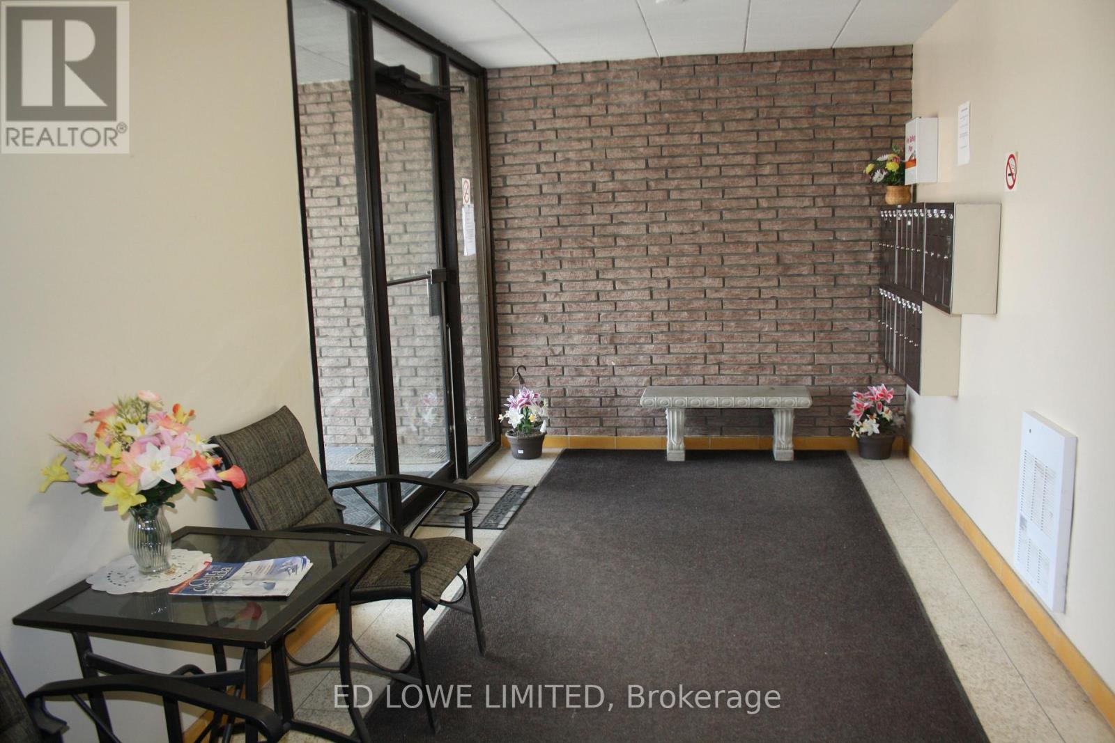 A brokerage office with a brick wall and a glass table.