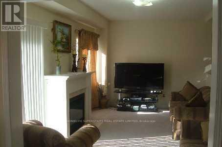 A living room with a fireplace, a couch, a television and a painting on the wall.