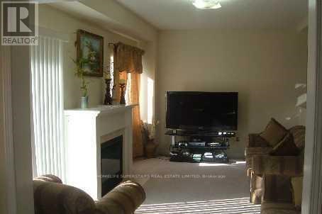 A living room with a fireplace, a couch, a television and a painting on the wall.