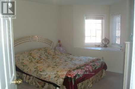 A bedroom with a floral bedspread and a window with blinds.
