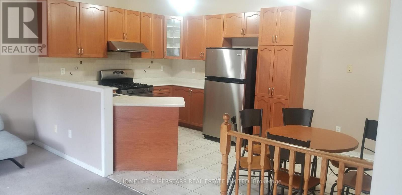 A kitchen with wooden cabinets and a table with chairs.