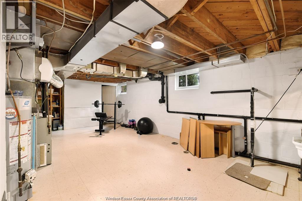 A spacious garage with a lot of unfinished work and a REALTOR sign.