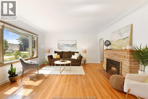 A living room with a fireplace and a painting on the wall.
