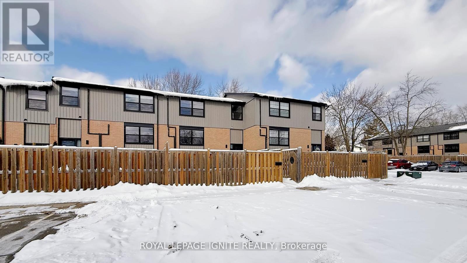 A building with a fence in front of it and snow on the ground.