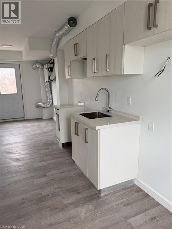 A kitchen with white cabinets and a sink.