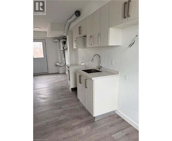 A kitchen with white cabinets and a sink.