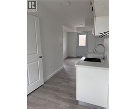 A kitchen with a sink and a door.