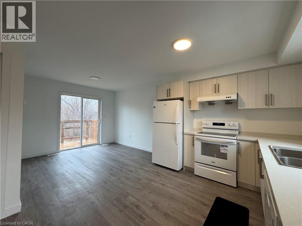 A kitchen with white appliances and wooden cabinets.