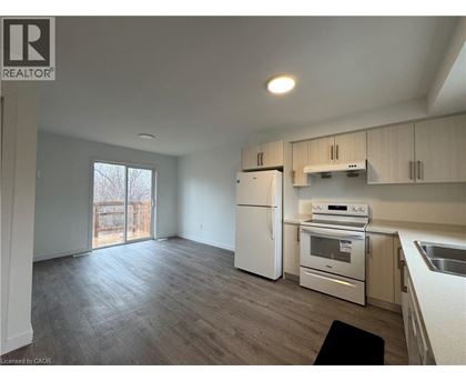 A kitchen with white appliances and wooden cabinets.