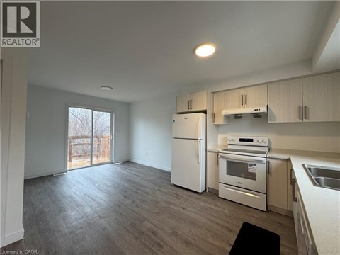 A kitchen with white appliances and wooden cabinets.