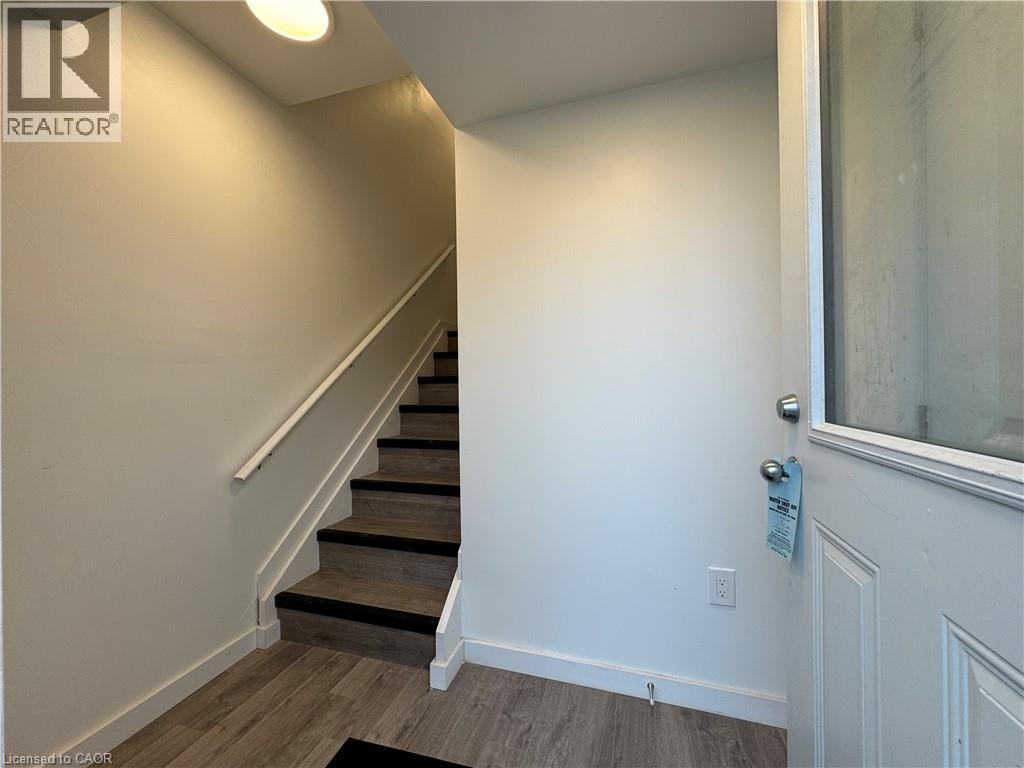 A hallway with a staircase and a door.