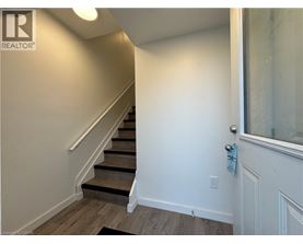 A hallway with a staircase and a door.