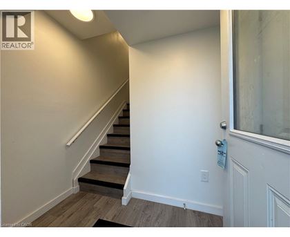 A hallway with a staircase and a door.
