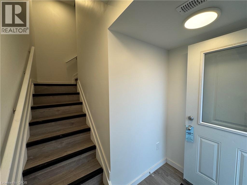 A staircase with a white door at the bottom.