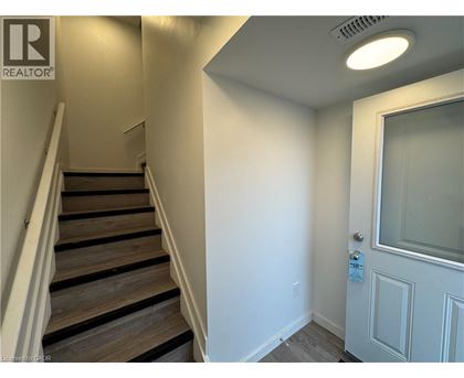 A staircase with a white door at the bottom.